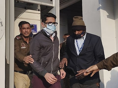 Policemen escort Shankar Mishra, arrested for being an unruly airline passenger, outside a court in New Delhi.a complaint by a woman aboard an Air India flight from New York that he urinated on her in business class. (AP Photo/Dinesh Joshi)