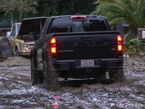 A truck drives along a muddy street in Felton, California.
