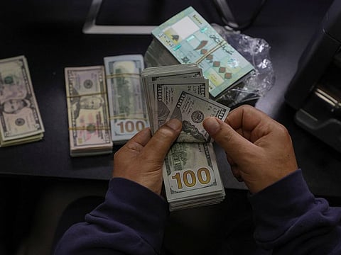 A money exchange vendor holds Lebanese pound banknotes at a shop in Beirut, Lebanon, January 19, 2023.  