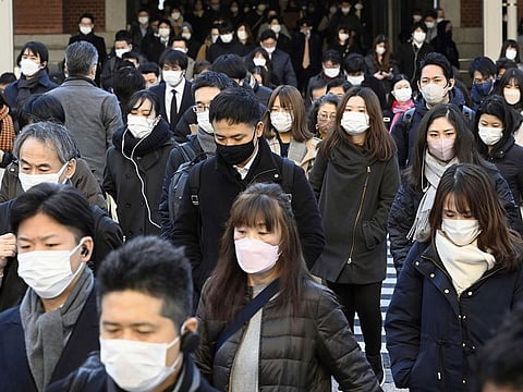 Commuters wear masks outside Tokyo Station in Tokyo on Friday, January 20, 2023. 