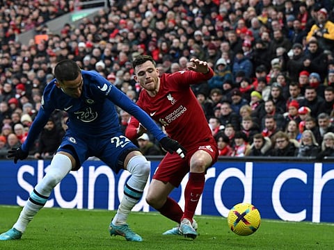 Chelsea's midfielder Hakim Ziyech (left) fights for the ball with Liverpool's defender Andrew Robertson during the English Premier League football match at Anfield in Liverpool, north west England.