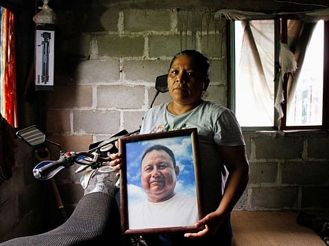 Marilu Sanchez holds a framed picture of her late husband Gustavo Sanchez, a journalist killed by assailants while riding his motorcycle with his son, at her home in Morro de Mazatan, in Oaxaca state, Mexico.