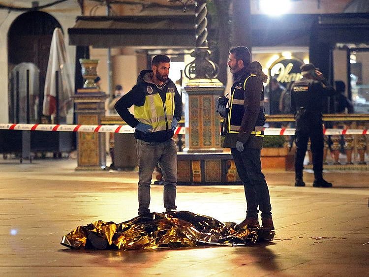 Graphic content: The body of a dead man lies on the ground as police secure the area in Algeciras, southern Spain.  
