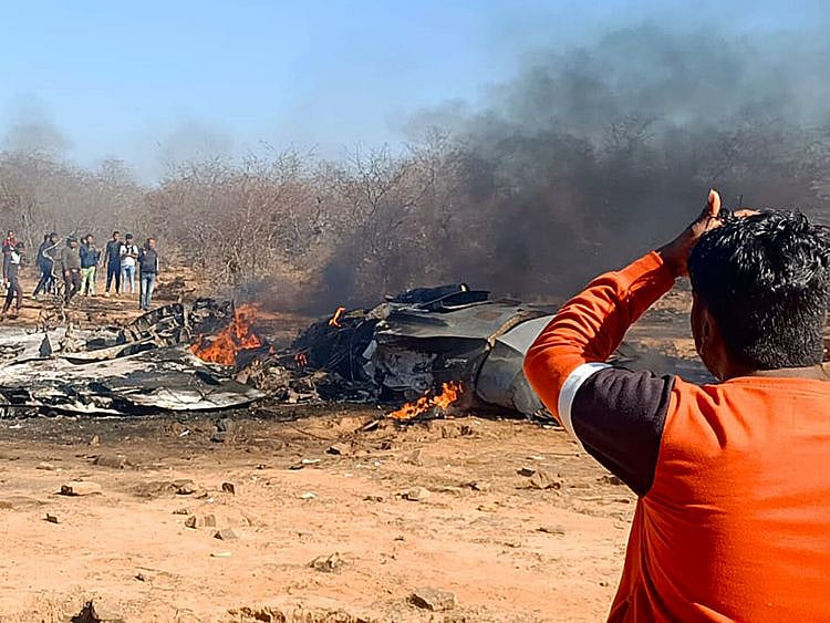 People gather near the wrecked remains after a Sukhoi-30 and Mirage 2000 aircraft