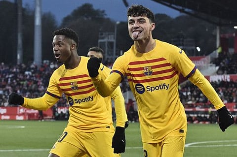 Barcelona's midfielder Pedri (right) celebrates scoring with Ansu Fati during the Spanish League match against Girona FC at the Montilivi stadium in Girona.