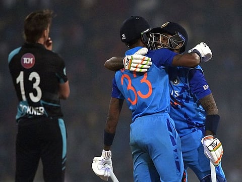 India's captain Hardik Pandya (C) and his teammate Suryakumar Yadav celebrate their win as New Zealand's Blair Tickner (L) watches at the end of the second Twenty20 international cricket match between India and New Zealand at the Ekana Cricket Stadium in Lucknow on January 29, 2023. 
