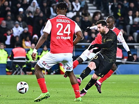 Paris Saint-Germain's Argentine forward Lionel Messi (right) shoots during the French L1 football match against Stade de Reims at the Parc des Princes stadium in Paris.