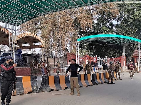 Security personnel stand guard outside the police headquarters after a blast in Peshawar on January 30, 2023.