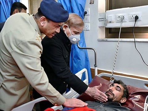 Pakistan's Prime Minister Shehbaz Sharif and Army Chief Gen. Asim Munir comfort an injured victim of suicide bombing, during their visit to hospital, in Peshawar.