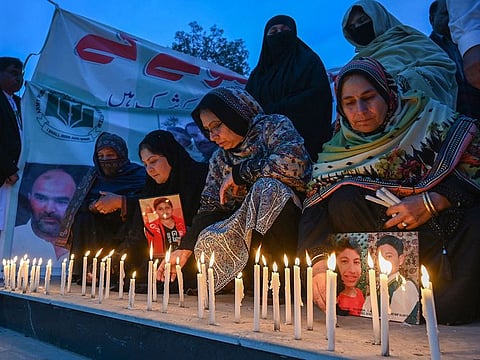 People light candles to pay tribute to the victims of a mosque suicide blast inside a police headquarters, in Peshawar on February 1, 2023. 