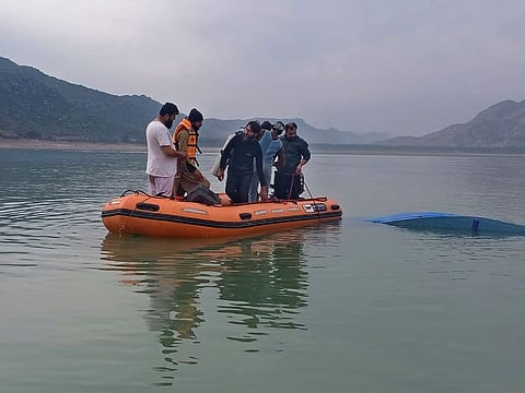In this photo provided by Khyber Pakhtunkhwa's provincial rescue department 'Rescue 1122', rescue workers search bodies following a boat caspisdwe in Tanda lake, in Kohat, in the northwest Pakistan.