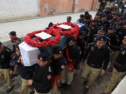 Police officers carry the coffin of Zareef Khan, who along with others was killed in a suicide blast at a mosque, during his funeral in Peshawar, Pakistan February 2, 2023.  