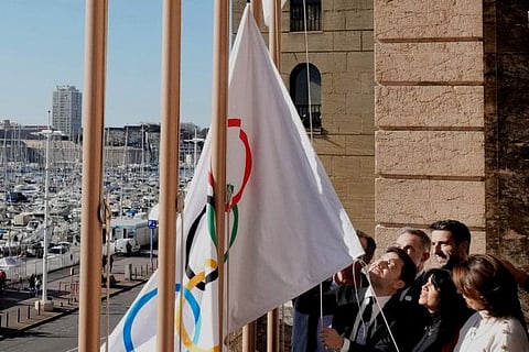 Mayor of Marseille Benoit Payan (centre) raises the Olympic flag with Head of Paris 2024 Olympics Tony Estanguet (center right) after a press conference at the Marseille City Hall, southern France, on Friday.