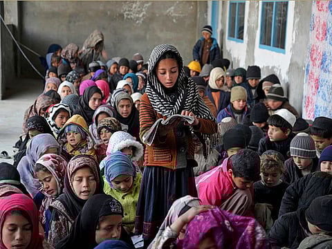 In this photograph taken on January 22, 2023, Afghan children take lessons at an open classroom in Dand district of Kandahar province. [Illustrative image]