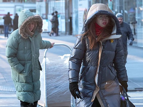 People bundled up against winter weather walk in midtown Manhattan as bitter cold temperatures moved into much of the northeast United States, on February 3, 2023. 