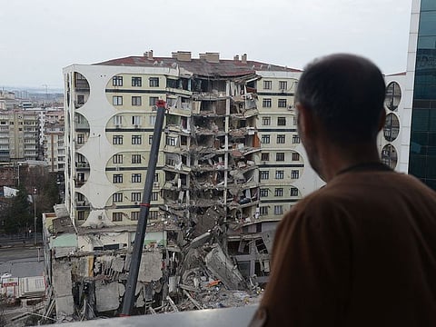 A man looks on at search and rescue operations conducted in the rubble of a collasped building in Diyarbakir.