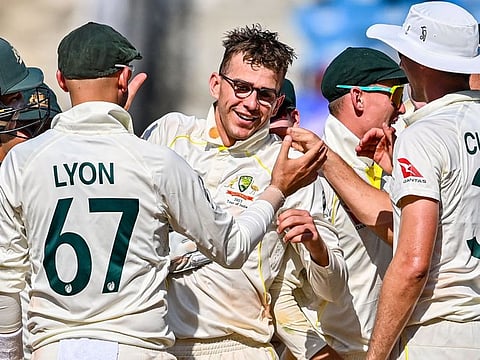 Australia's players celebrates with teammate Todd Murphy (C) after his fifth wicket of India's Srikar Bharat.