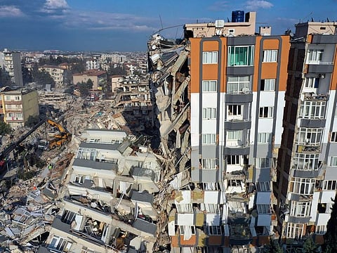 Cranes remove debris next to destroyed buildings in Antakya, southeastern Turkey, Friday, Feb. 10, 2023. Rescuers pulled several earthquake survivors from the shattered remnants of buildings Friday, including some who lasted more than 100 hours trapped under crushed concrete