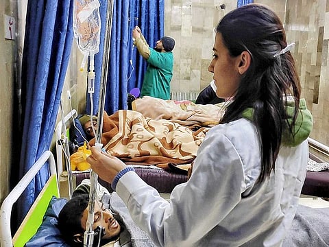 A handout picture released by the official Syrian Arab News Agency (SANA) on February 12, 2023, shows medics caring for people injured in a Daesh attack earlier in central Syria, at a hospital in Palmyra city. 