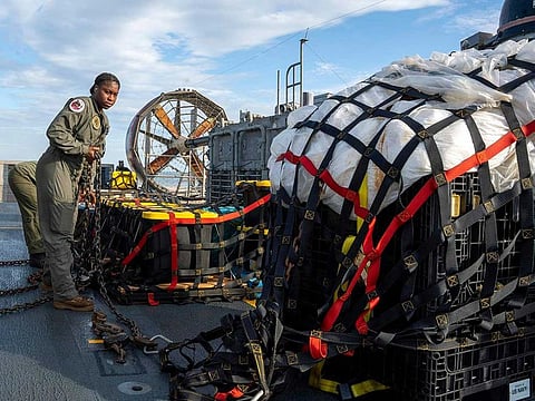 In this image released by the US Navy, sailors assigned to Assault Craft Unit 4 prepare material recovered off the coast of Myrtle Beach, S.C., in the Atlantic Ocean from the shooting down of a Chinese high-altitude balloon, for transport to the FBI, at Joint Expeditionary Base Little Creek in Virginia Beach, Va., on Feb. 10, 2023. The federal government's lack of information about four aerial objects recently shot down over North America is helping to fuel conspiracy theories and conjecture on the internet. 