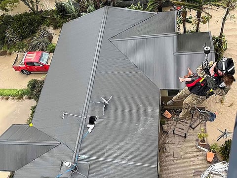 A child is winched from a rooftop of a home to safety by helicopter in the Esk Valley, near Napier, New Zealand.