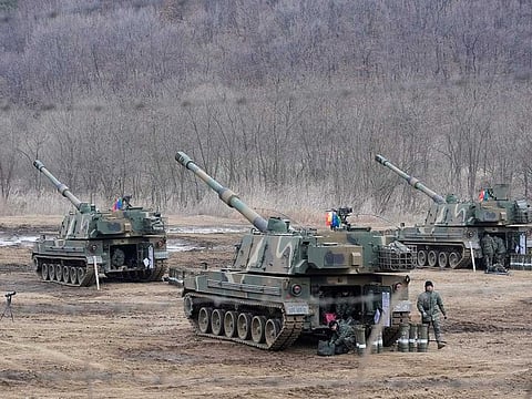 South Korean army soldiers work by K-9 self-propelled howitzers in Paju, South Korea, near the border with North Korea, Thursday, Feb. 16, 2023. 
