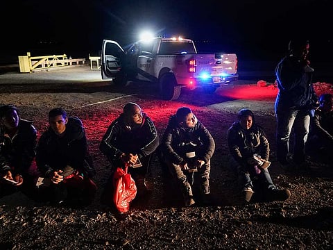 Migrants wait to be processed after crossing the border near Yuma, Arizona. 