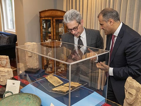 Chase Robinson, director of the Asian art museum’s Freer and Sackler galleries, left, examines artefacts with Yemeni Ambassador Mohammad Al Hadhrami during Tuesday's repatriation ceremony.  