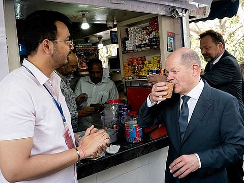 German Chancellor Olaf Scholz drinks tea at a shop on a street corner of Chanakyapuri, in New Delhi on Sunday, February 26, 2023. 