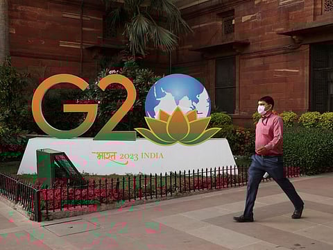 A man walks past a model of G20 logo outside the finance ministry in New Delhi, India, March 1, 2023.