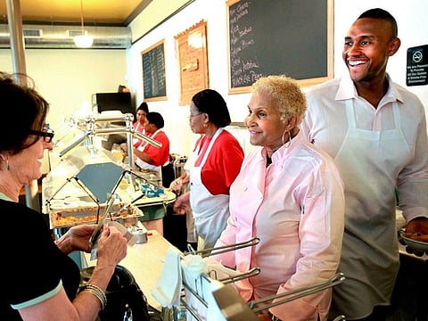 FILE - A customer picks up some food to-go from Sweetie Pie's owner Robbie Montgomery, center, and Montgomery's son, James "Tim" Norman, right, at Sweetie Pie's in St. Louis, April 19, 2011. Norman, the former star of a St. Louis-based television reality show, was sentenced Thursday, March 2, 2023, to life in prison for arranging the shooting death of his nephew to collect a life insurance payment. (David Carson/St. Louis Post-Dispatch via AP, File)