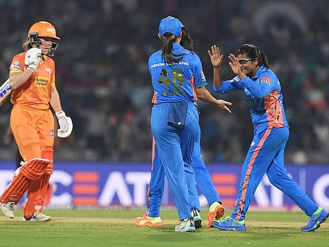 Mumbai Indians' Saika Ishaque (right) celebrates with teammates after the dismissal of Gujarat Giants' Georgia Wareham (L) during the 2023 Women's Premier League (WPL) Twenty20 cricket match at the DY Patil Stadium in Navi Mumbai on March 4, 2023.  