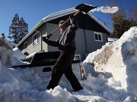 A resident shovels snow after a series of winter storms dumped heavy snowfall in the San Bernardino Mountains in Southern California on March 3, 2023.