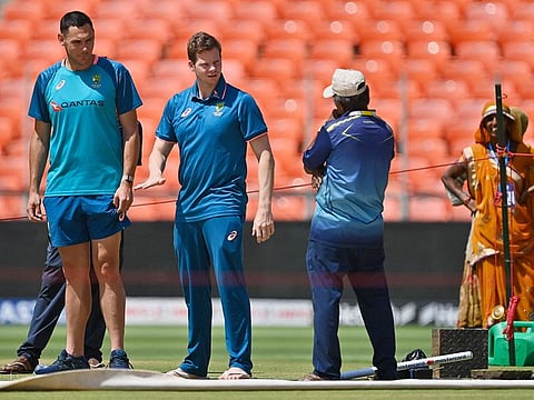 Australia’s Steven Smith (2L) speaks with ground staff at the pitch of the Narendra Modi stadium in Ahmedabad on March 8, 2023, ahead of their fourth and final Test cricket match against India.  