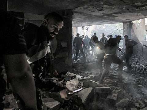 People inspect the wreckage of a building that was housing a group of militants and was hit by rockets during an Israeli army raid in the Jenin camp for Palestinian refugees in the occupied West Bank on March 7, 2023.  