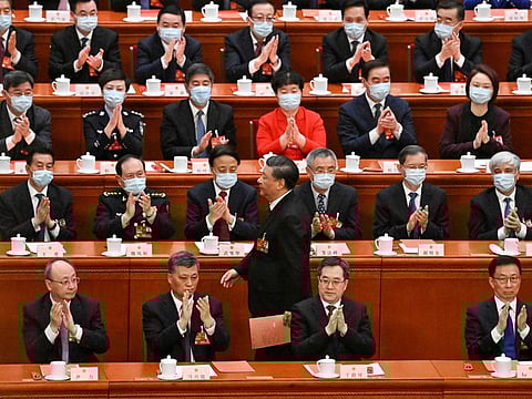 China's President Xi Jinping (centre) walks past delegates as he prepares to vote during the third plenary session of the National People's Congress (NPC) at the Great Hall of the People in Beijing on March 10, 2023.  