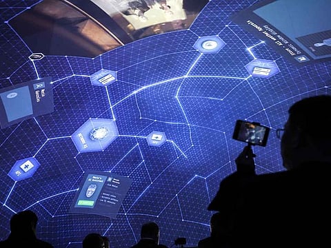 An attendee films a rooftop artificial intelligence (AI) presentation on a smartphone at the Ericsson AB stand on the opening day of the Mobile World Congress at the Fira de Barcelona venue in Barcelona, Spain, in February.