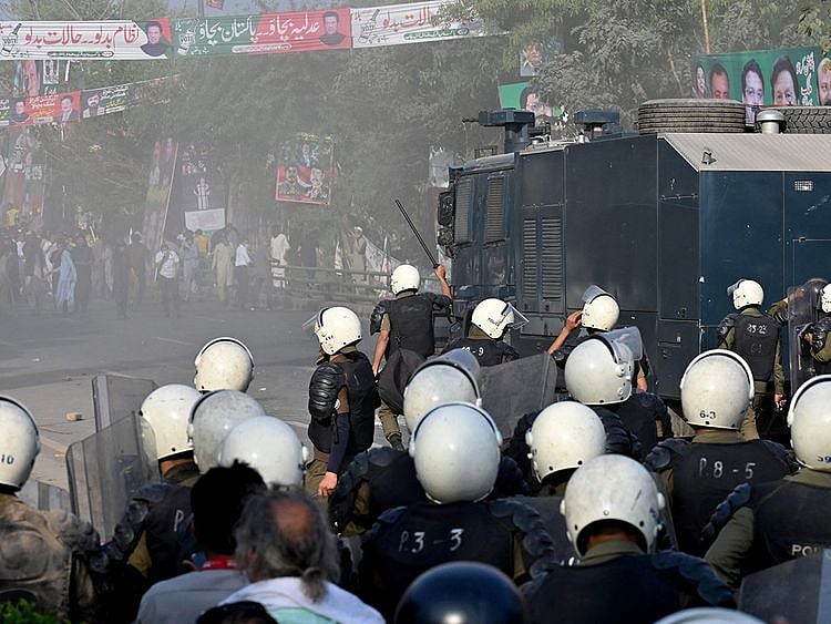 Riot police use water cannon to push back supporters of former prime minister Imran Khan gathered outside Khan's house to prevent officers from arresting him, in Lahore on March 14, 2023.  