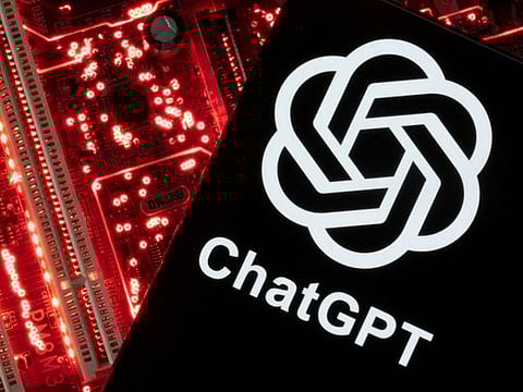 A smartphone with a displayed ChatGPT logo is placed on a computer motherboard in this illustration. 