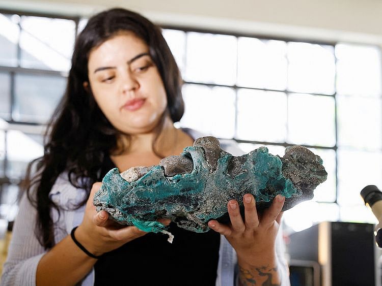 Researcher Fernanda Avelar Santos holds "plastic rocks" 
