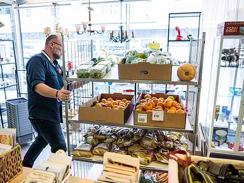 A man is seen preparing donated food items from local supermarkets to be sold at reduced prices in a Red Cross branch on March 14, 2023, in Stockholm, Sweden.