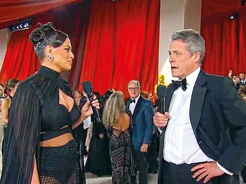 Hugh Grant is interviewed on the 2023 Oscars red carpet by model Ashley Graham that went viral.