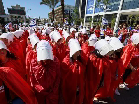 Unmissable in the crowd are the women in red robes, turning otherwise usual protest scenes into an otherworldly sight.