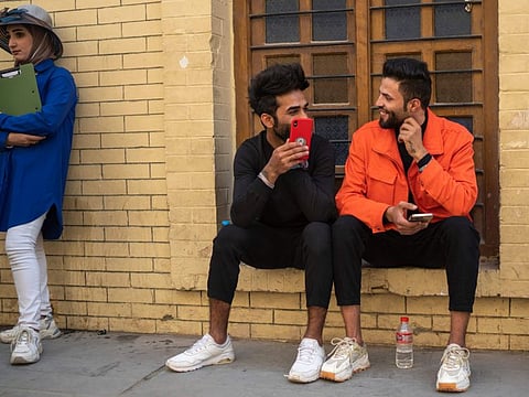 Young men chat near Al Mutanabbi street in Baghdad.  