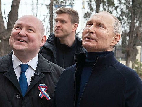This handout photograph taken and released by the Russian presidential press office in Sevastopol on March 18, 2023, shows Russian President Vladimir Putin (R), talking to Sevastopol Governor Mikhail Razvozhayev (L), as he visits the Chersonesos Taurica historical and archeological park on the 9th anniversary of the referendum on the state status of Crimea and Sevastopol and its reunification with Russia. 