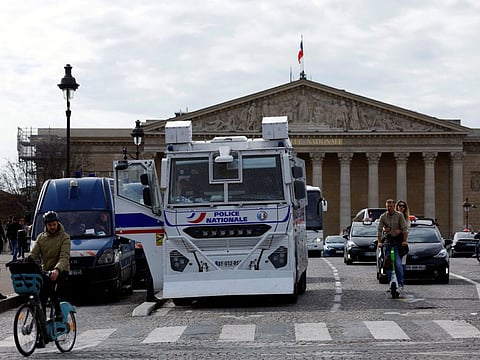 French police stand in front of the National Assembly before debates and votes on two motions of no-confidence against the French government, tabled by centrist group Liot and far-right Rassemblement National party, after the use by French government of the article 49.3, a special clause in the French Constitution, to push the pensions reform bill through the National Assembly without a vote by lawmakers, in Paris, France, March 20, 2023.