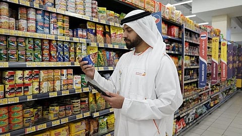 A municipality inspector checking a food product at a retailer in Dubai 