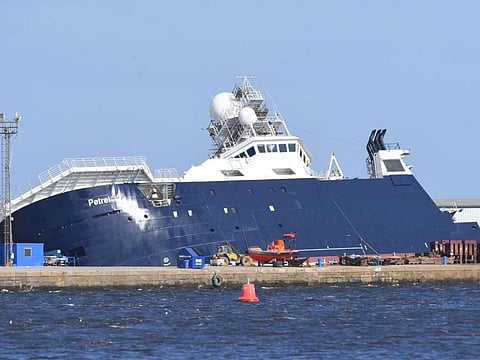 Emergency teams attend the scene after a ship, the research vessel the 'Petrel', tipped over at a 45-degree angle in the Imperial Dock area in Leith, Scotland on March 22, 2023.
