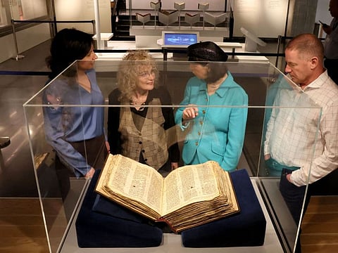 People look at the Codex Sassoon, the earliest most complete edition of the Hebrew Bible, on March 22, 2023 at the ANU Museum of the Jewish People in Tel Aviv.  