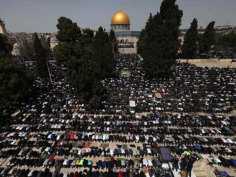 People perform the first Friday noon prayer of Ramadan in front of the Dome of the Rock shrine at the Al Aqsa mosque compound in Jerusalem, on March 24, 2023.  